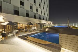 a swimming pool with a table and chairs and a building at Movich Buro 51 in Barranquilla