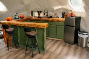 a kitchen in a tent with a counter and stools at Romantic Dome Retreat for Couples in Ellijay