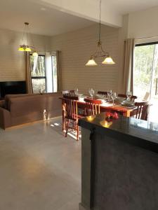 a living room with a table and chairs and a couch at Casa Beija-flor no Vale do Capão in Palmeiras +58 photos
