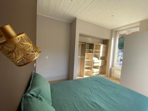 Un dormitorio con una cama y una luz en la pared. en La soie, en Allevard 2 fotos más