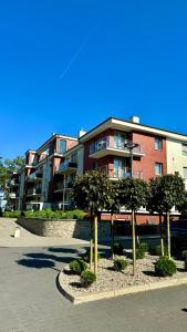 un grupo de árboles frente a un edificio en Apartament Scandi, basen & spa, en Rewal