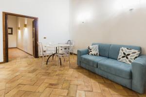 a living room with a blue couch and a table at ErbeHouse in Tivoli +11 photos