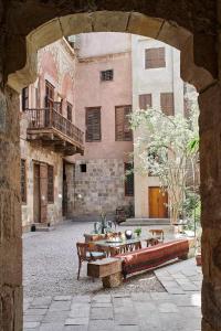 un edificio in pietra con tavoli e panche di fronte ad esso di Old Boutique Palace Accomodation in Cairo R#6789Flat a Il Cairo