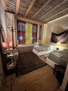 una camera con due letti e un tavolo e due finestre di Old Boutique Palace Accomodation in Cairo R#6789Flat a Il Cairo