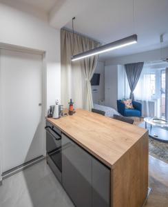 a kitchen with a counter top and a living room at Studio apartman Kvaternik in Zagreb