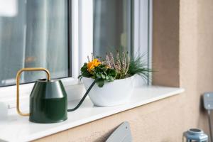 a window sill with two plants and a watering can at Studio apartman Kvaternik in Zagreb