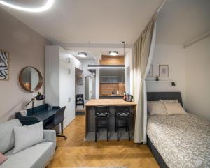 a bedroom with a bed and a desk and a kitchen at Studio apartman Kvaternik in Zagreb