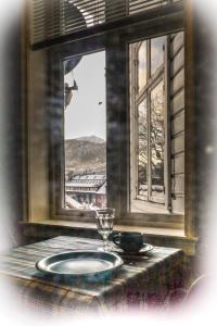 una mesa con un plato y un vaso delante de una ventana en Amunds Apartment en Bergen