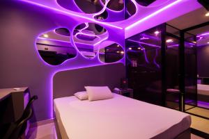 a room with a bed with purple lights on it at Adrenalina Motel Itaquera - Arena Corinthians in Sao Paulo