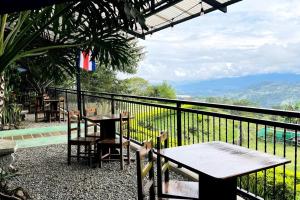 a table and chairs on a balcony with a view at Cabaña La Finca in Cervantes