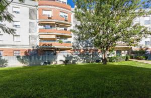 a tree in a yard in front of a building at Amplio y Luminoso 3 Rooms Parking in Jerez de la Frontera +12 photos