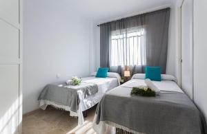 a room with two beds and a window at Amplio y Luminoso 3 Rooms Parking in Jerez de la Frontera