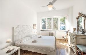 a white bedroom with a bed and a window at Villa Valentini in San Michele di Pagana