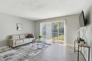 Una sala de estar con un sofá y un televisor. en Barcelo At East Cobb Q1 1 Bed 1 Bath Furnished, en Marietta