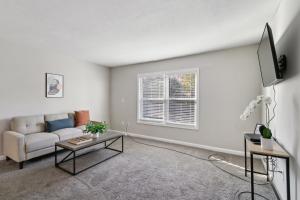 Una sala de estar con un sofá y un televisor. en Barcelo At East Cobb Q5 1 Bd 1bth Newly Furnished, en Marietta