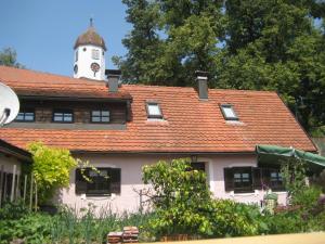 Una casa blanca con una torre de reloj encima. en Ferienhaus Fam. Fuhrer, en Hohenaltheim
