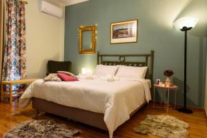 a bedroom with a bed with white sheets and a mirror at Joanna's city centre apartment in Tripoli