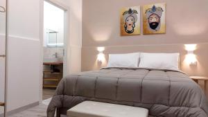 a bedroom with a bed with two paintings on the wall at Il Sogno Siciliano in Mazara del Vallo