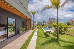 a backyard with a pool and a palm tree at Summerville #117 - Luxo no Cumbuco by Carpediem in Cumbuco