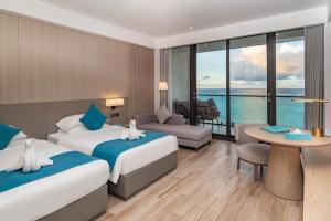 Una habitación de hotel con dos camas y vista al mar. en Palau Sunrise Seaview Landison Retreat, en Melekeok