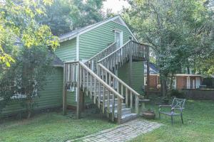 a small green house with a staircase next to a house at The Loft at Park Place Cozy Studio on the Park in Columbus