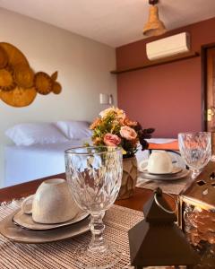 a table with plates and glasses on top of a room at Pousada Recanto do Luar in Serra de São Bento