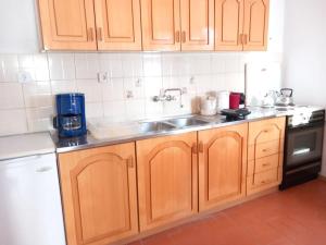 a kitchen with wooden cabinets and a sink at Το μπαλκόνι της Βεγορίτιδας in Agios Panteleimon +17 photos