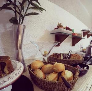 a table topped with baskets of bread and cakes at Ipê Rosa Hotel in Bauru