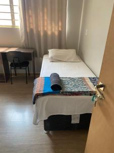 a bed in a room with a door open at Ipê Rosa Hotel in Bauru