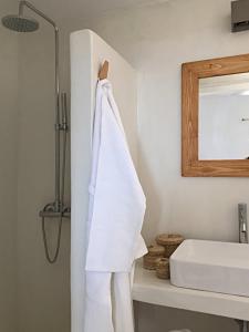 Stunning Antiparos Villa 3 Bedrooms Villa Kamino Breathtaking Sea Views في أنديباروس: حمام مع منشفة بيضاء معلقة على الحائط