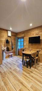 a dining room with a table and a flat screen tv at Essencia, gîte dans les collines de Toulon in Toulon