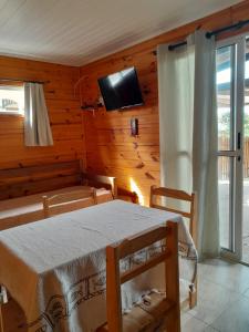 a room with a table and a tv on the wall at Cabaña Gabon in Barra del Chuy