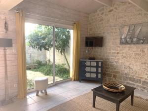 a living room with a large sliding glass door at Petite maison de village Eloise proche de la plage in Sainte-Marie-de-Ré