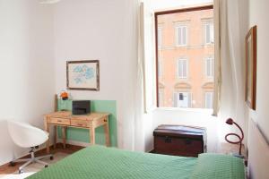 a bedroom with a bed and a desk and a window at Shangrila in Rome