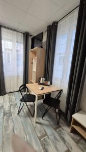 a table and two chairs in a room with windows at Guest House "The House" Топ Център Габрово in Gabrovo