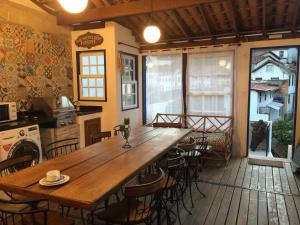 Viva Chico Rei Hostel في أورو بريتو: طاولة خشبية كبيرة في مطبخ مع كراسي