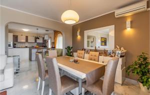 une salle à manger et une cuisine avec une table et des chaises dans l'établissement Three-Bedroom Apartment In Vodnjan, à Mednjan