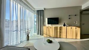 Una sala de estar con televisión y una gran ventana. en Apartament Scandi, basen & spa, en Rewal