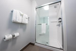a bathroom with a glass shower stall with towels at avid hotel Kalamazoo East by IHG in Kalamazoo +44 photos