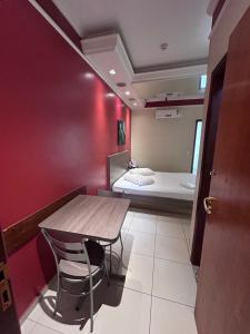 a small room with a table and a bed at Alpha Motel in Amparo +1 photo