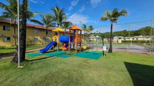 a playground with a slide in a yard with palm trees at JL Temporadas - Quarto Portobello Park Hotel in Porto Seguro