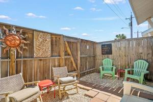 a patio with chairs and a wooden fence at Walk to Beach Shared Pool & Grill Dog Friendly in Padre Island
