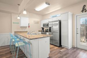 a kitchen with a sink and a refrigerator at Walk to Beach Shared Pool & Grill Dog Friendly in Padre Island +24 photos