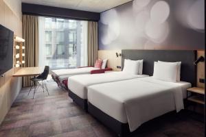 a hotel room with two beds and a desk at STAGES HOTEL Prague, a Tribute Portfolio Hotel in Prague