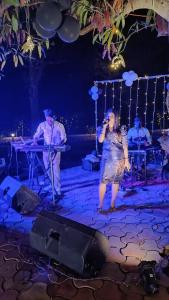 a woman standing on a stage with a microphone at The Royal River Resort in Keonchi