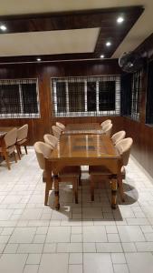 a conference room with a wooden table and chairs at The Royal River Resort in Keonchi
