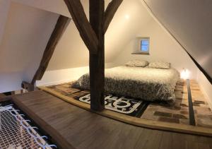 ein Schlafzimmer mit einem Bett auf einem Dachboden in der Unterkunft Pantouflard - Maison entière in Toucy