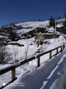 a bridge covered in snow next to a house at Quirós Villa Tranquila de Salcedo 1 in La Villa