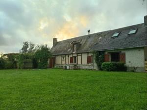 an old house with a grass yard in front of it at Chez Johns in Bailleul-Neuville