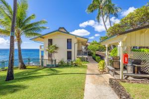 a house on the beach with palm trees at Poipu Shores 101B in Koloa
